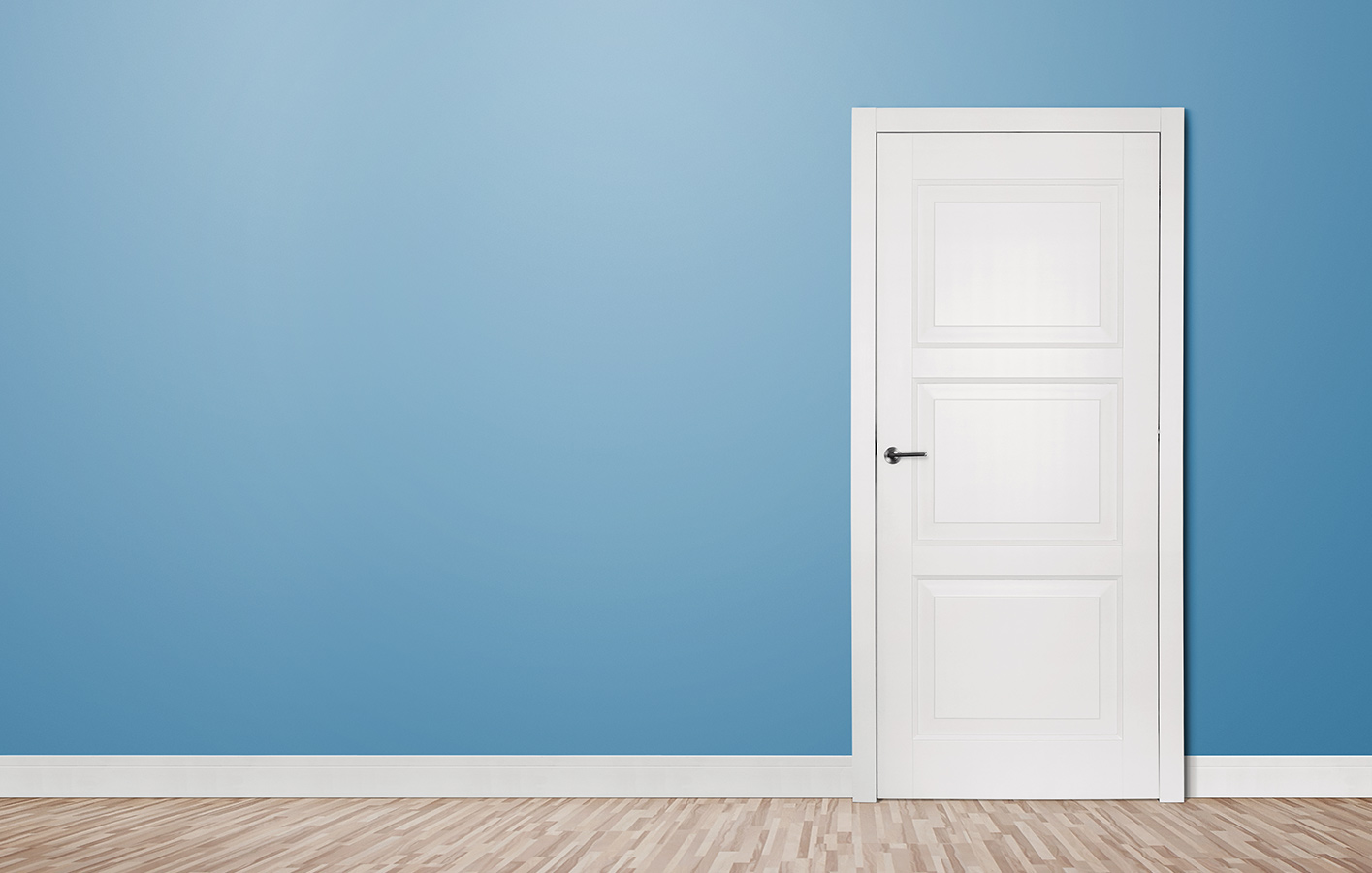 Weiße Zimmertür mit einer blauen Wand.