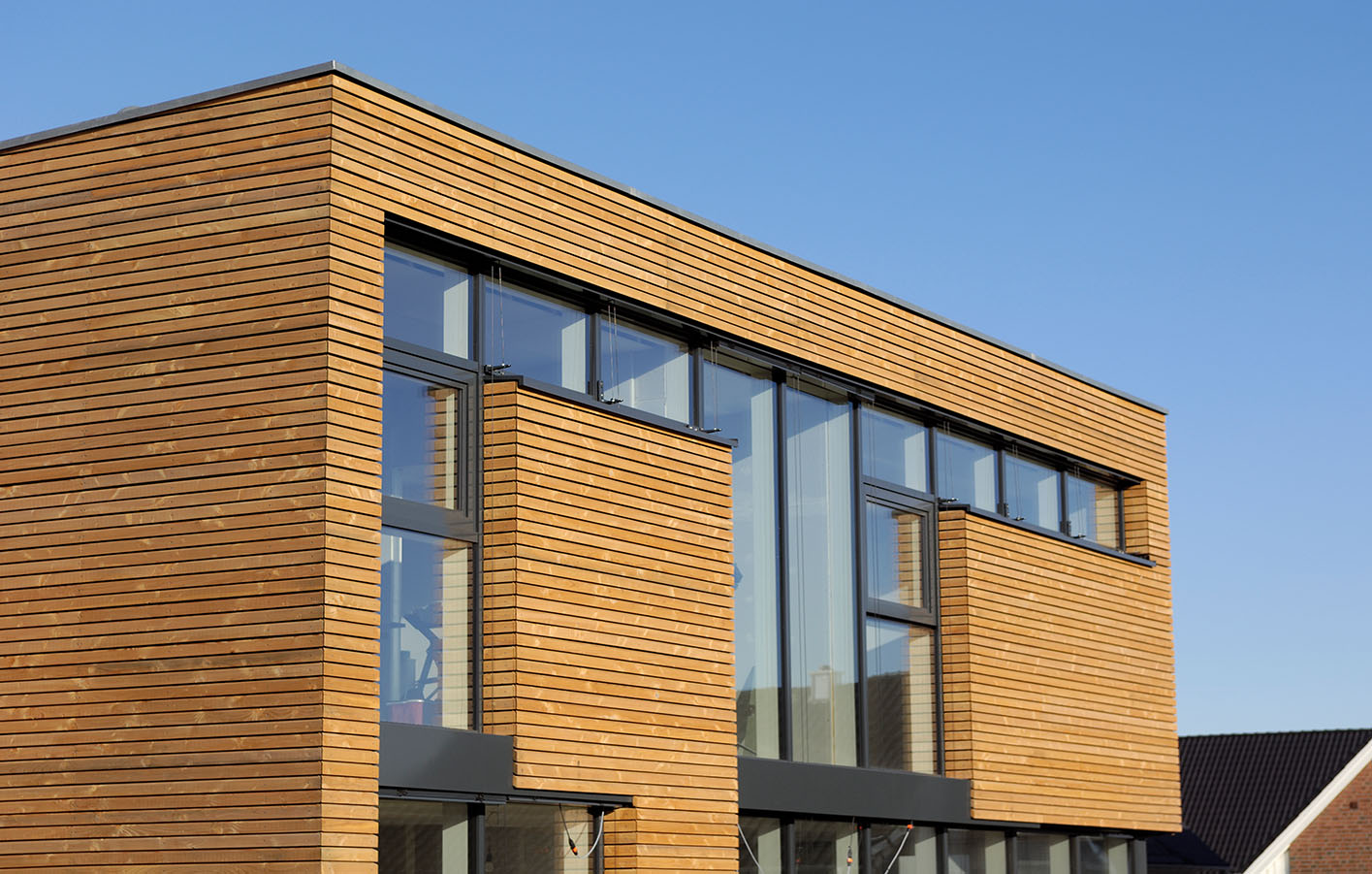 Holzfassade mit großer Fensterfront.